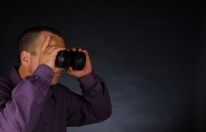 a man in a purple shirt is holding a camera