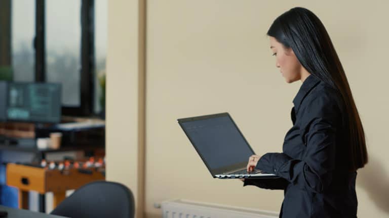 a woman is using a laptop computer in an office